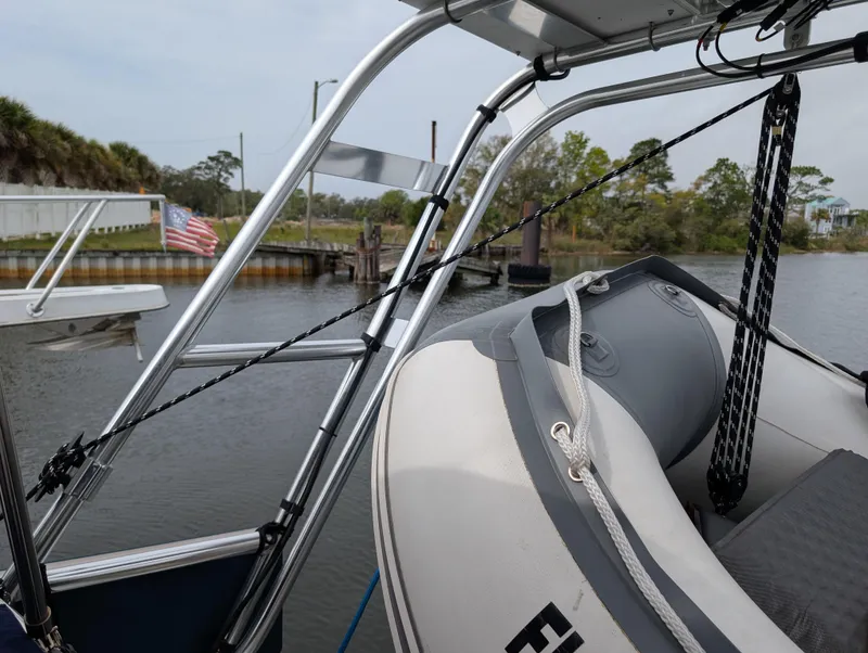 Slide: The Image of Beneteau Oceanis 473 sailboat with dinghy, docked in a serene marina, 2003 model. - 38