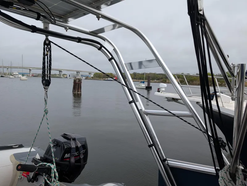 Slide: The Image of 2003 Beneteau Oceanis 473 sailboat with marina view, featuring metal framework and outboard motor. - 39