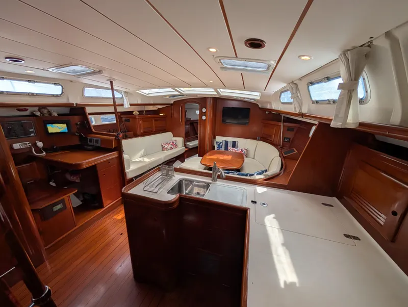 Slide: The Image of Interior of 2003 Beneteau Oceanis 473 yacht with wood finish and seating area. - 4