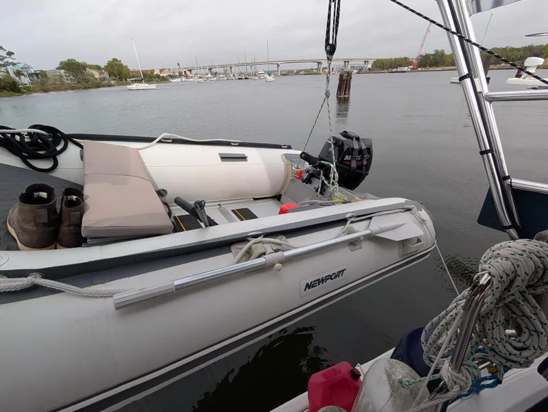 Slide: The Image of Inflatable dinghy moored beside a 2003 Beneteau Oceanis 473 sailboat on a calm river. - 40