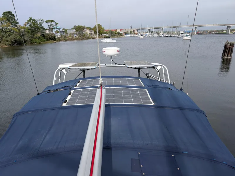 Slide: The Image of Beneteau Oceanis 473 sailboat with solar panels on deck, docked in a serene marina. - 42