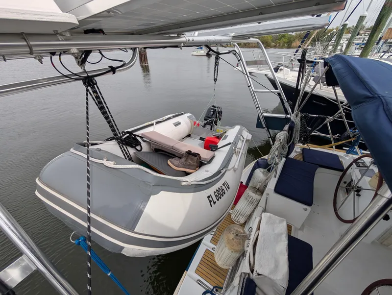 Slide: The Image of 2003 Beneteau Oceanis 473 sailboat with dinghy on davits, docked in a marina. - 43