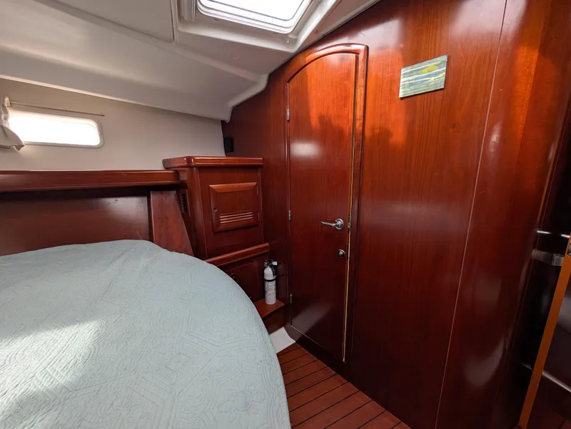 Slide: The Image of Interior cabin of 2003 Beneteau Oceanis 473 yacht with wooden finish and bed. - 9