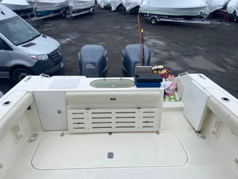 Slide: The Image of 2007 Pursuit 335 Offshore boat deck with twin engines and storage compartments. - 10