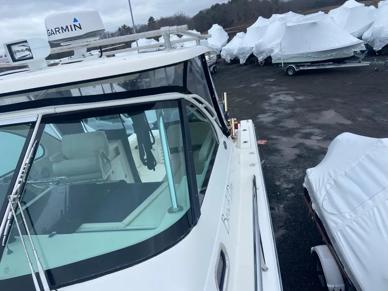 Slide: The Image of 2007 Pursuit 335 Offshore boat in storage yard, covered vessels in background. - 17