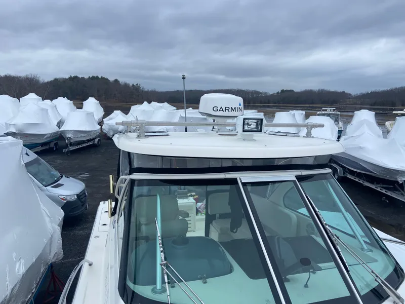 Slide: The Image of 2007 Pursuit 335 Offshore boat with Garmin radar, docked among covered boats. - 20