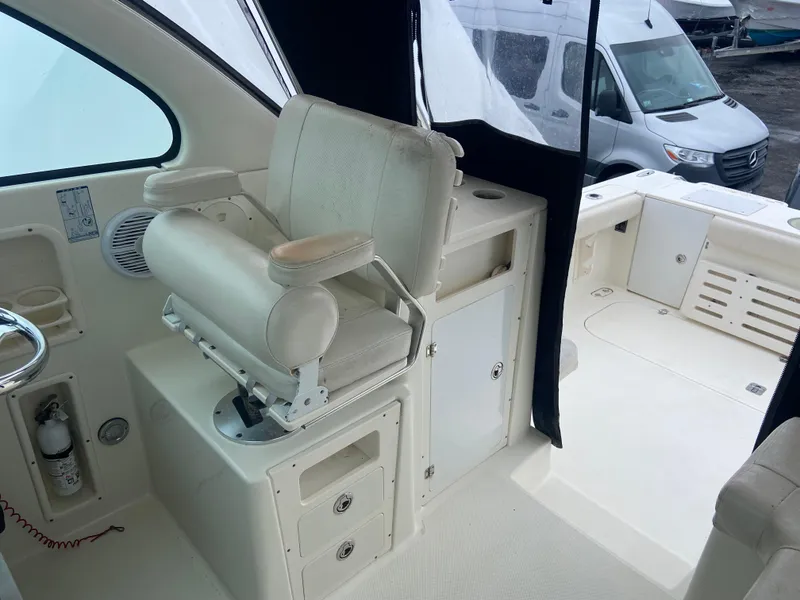 Slide: The Image of 2007 Pursuit 335 Offshore boat interior with helm seat and storage compartments. - 24