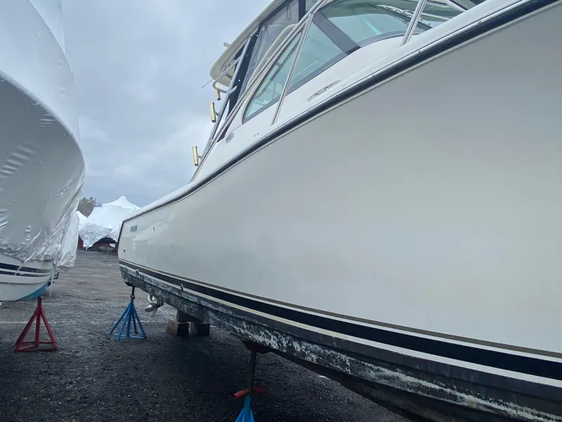 Slide: The Image of 2007 Pursuit 335 Offshore boat on stands, side view, overcast sky. - 3