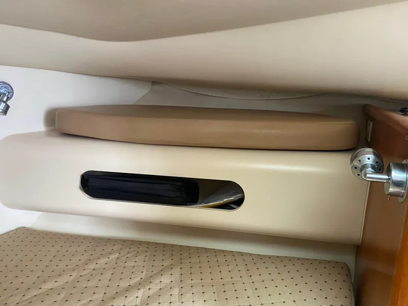 Slide: The Image of 2007 Pursuit 335 Offshore cabin interior with beige seating and storage compartment. - 43