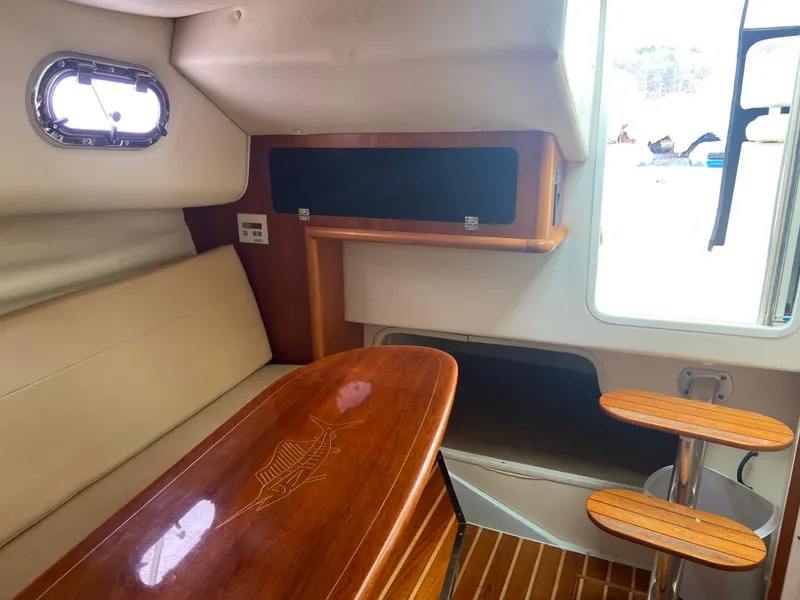 Slide: The Image of 2007 Pursuit 335 Offshore cabin interior with wooden table and seating. - 46