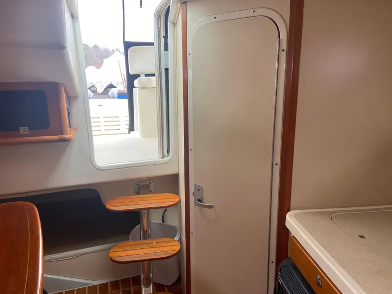 Slide: The Image of Interior of 2007 Pursuit 335 Offshore boat, featuring cabin door and wooden accents. - 47