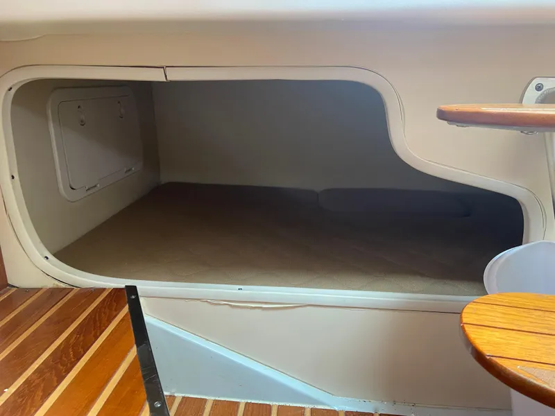 Slide: The Image of 2007 Pursuit 335 Offshore cabin interior with wooden flooring and compact sleeping area. - 48
