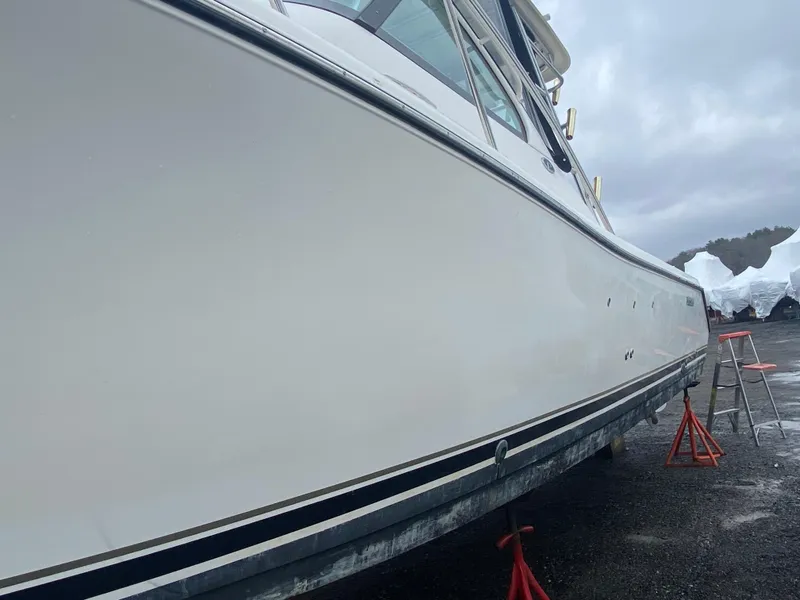 Slide: The Image of 2007 Pursuit 335 Offshore boat on stands, side view, overcast sky. - 6