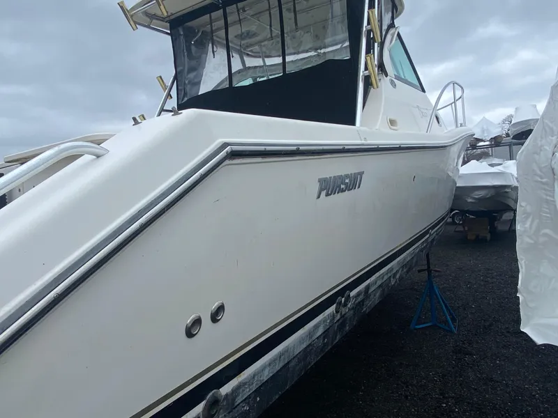 Slide: The Image of 2007 Pursuit 335 Offshore boat on land, side view, overcast sky. - 7