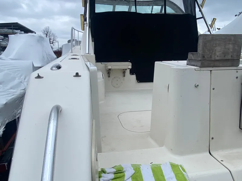 Slide: The Image of 2007 Pursuit 335 Offshore boat deck with striped towel, under cloudy sky. - 9