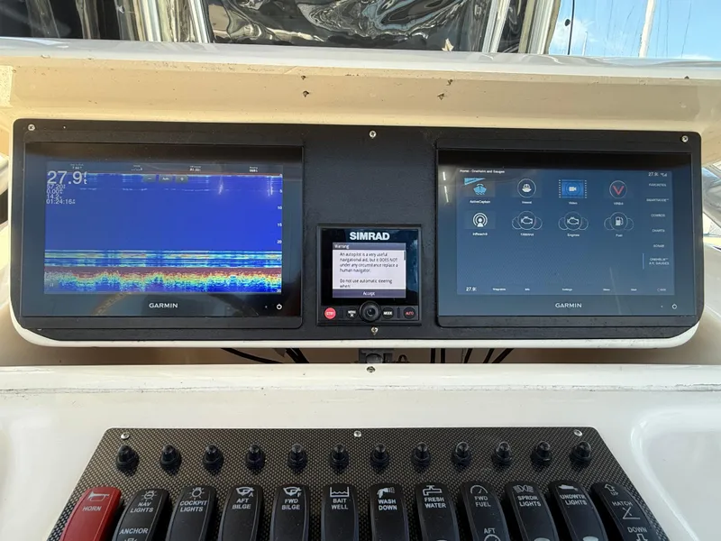 Slide: The Image of 2005 Grady-White Bimini 306 dashboard with Garmin and Simrad displays. - 11