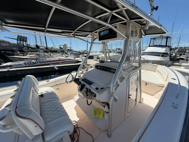 Slide: The Image of 2005 Grady-White Bimini 306 boat interior at marina, featuring helm and seating. - 12