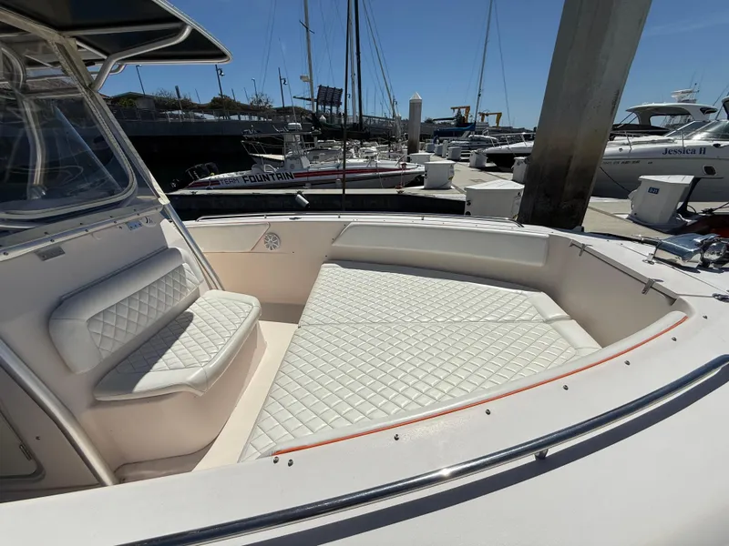 Slide: The Image of 2005 Grady-White Bimini 306 boat with white cushioned seating at a marina. - 13