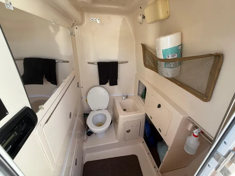 Slide: The Image of 2005 Grady-White Bimini 306 boat bathroom with toilet, sink, and storage compartments. - 14