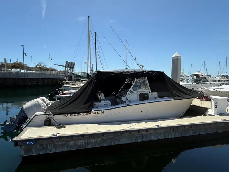 Slide: The Image of 2005 Grady-White Bimini 306 boat docked with cover, marina background. - 16