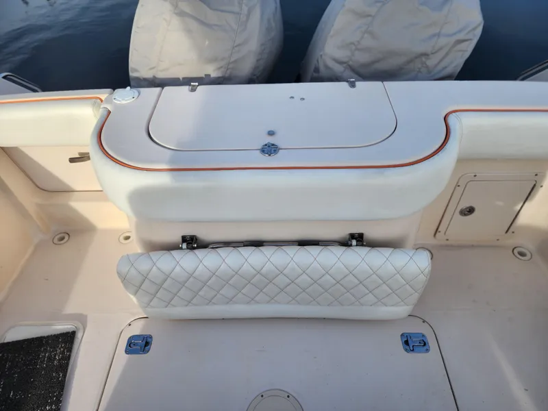 Slide: The Image of 2005 Grady-White Bimini 306 boat interior with cushioned seating and storage compartments. - 21