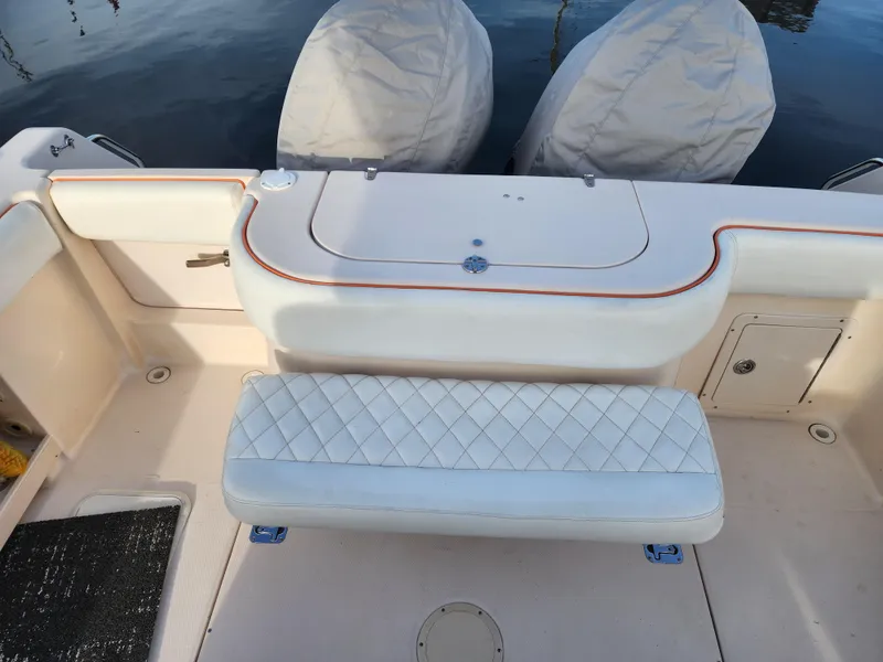 Slide: The Image of 2005 Grady-White Bimini 306 boat interior with cushioned seating and covered engines. - 22