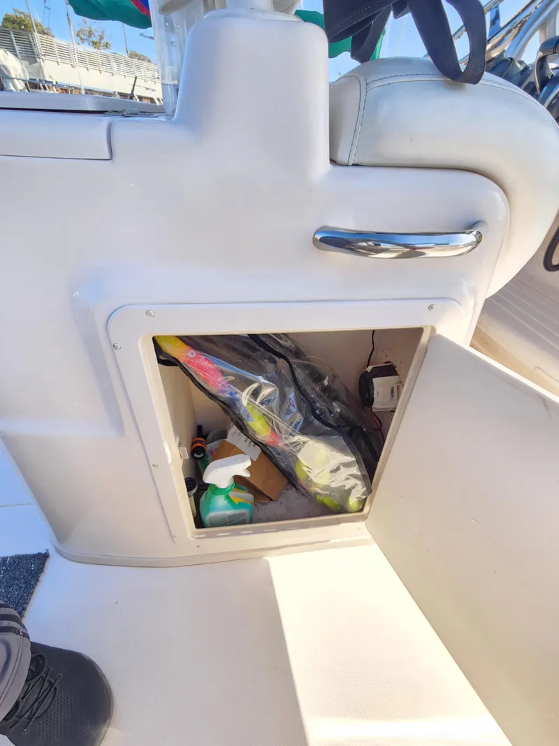 Slide: The Image of Storage compartment on a 2005 Grady-White Bimini 306 boat, containing various items. - 27