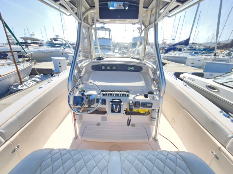 Slide: The Image of 2005 Grady-White Bimini 306 boat cockpit with steering wheel and controls, docked at marina. - 31