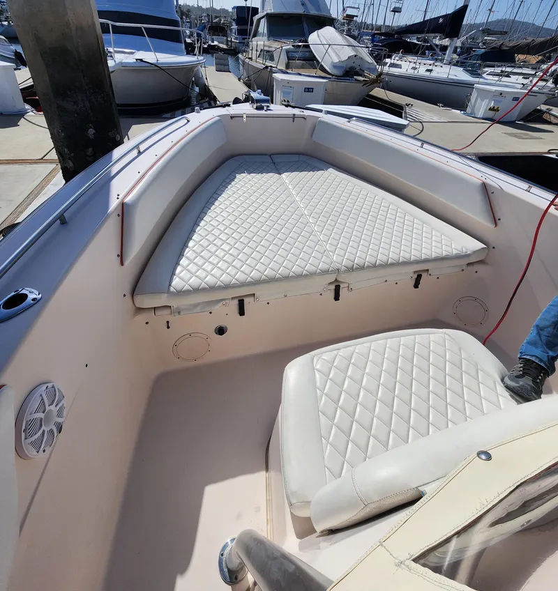 Slide: The Image of 2005 Grady-White Bimini 306 boat interior with cushioned seating at a marina. - 41