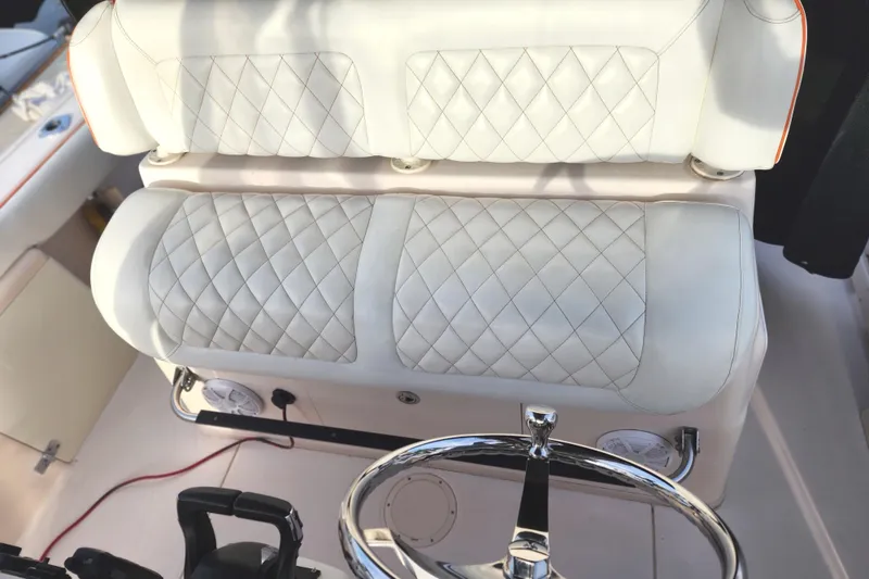 Slide: The Image of 2005 Grady-White Bimini 306 boat interior with quilted white seating and steering wheel. - 45