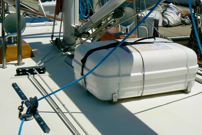 Slide: The Image of 1999 Pacific Seacraft 40 Voyagemaker interior with wood finish, teal seating, and kitchen sink. - 16