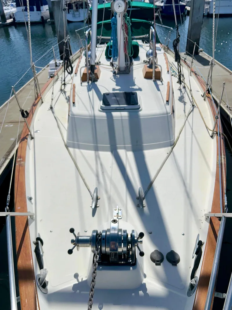 Slide: The Image of 1999 Pacific Seacraft 40 Voyagemaker sailboat docked in marina, featuring green canopy and sleek design. - 6