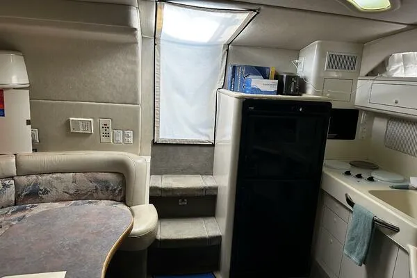 Slide: The Image of Interior of a 1996 Sea Ray 400 Express Cruiser with kitchenette and seating area. - 10