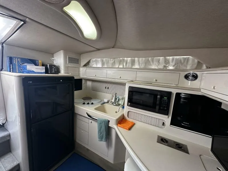 Slide: The Image of Interior of 1996 Sea Ray 400 Express Cruiser kitchen with appliances and storage. - 12