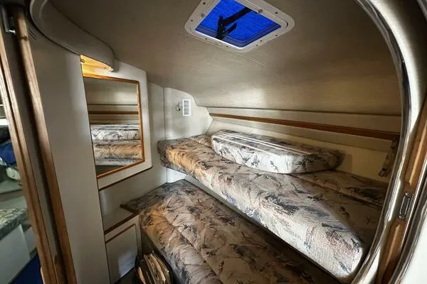 Slide: The Image of Interior cabin of 1996 Sea Ray 400 Express Cruiser with bunk beds and mirror. - 13