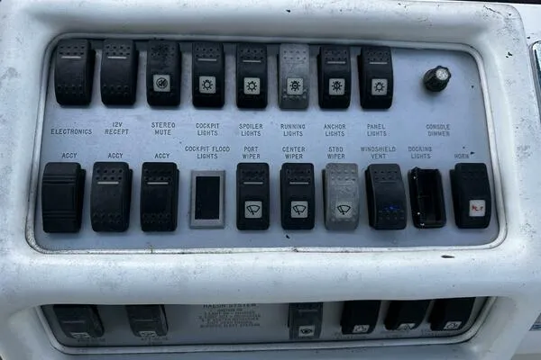 Slide: The Image of Control panel of a 1996 Sea Ray 400 Express Cruiser with various switches and labels. - 18