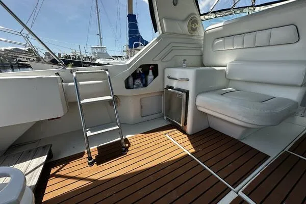 Slide: The Image of 1996 Sea Ray 400 Express Cruiser interior with seating, ladder, and wooden deck. - 23