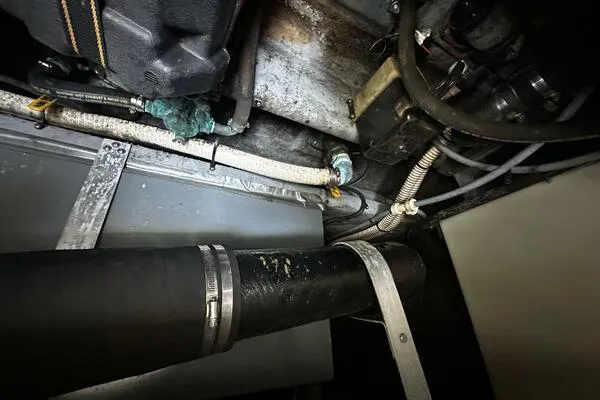 Slide: The Image of Engine compartment of a 1996 Sea Ray 400 Express Cruiser, showing hoses and metal components. - 36