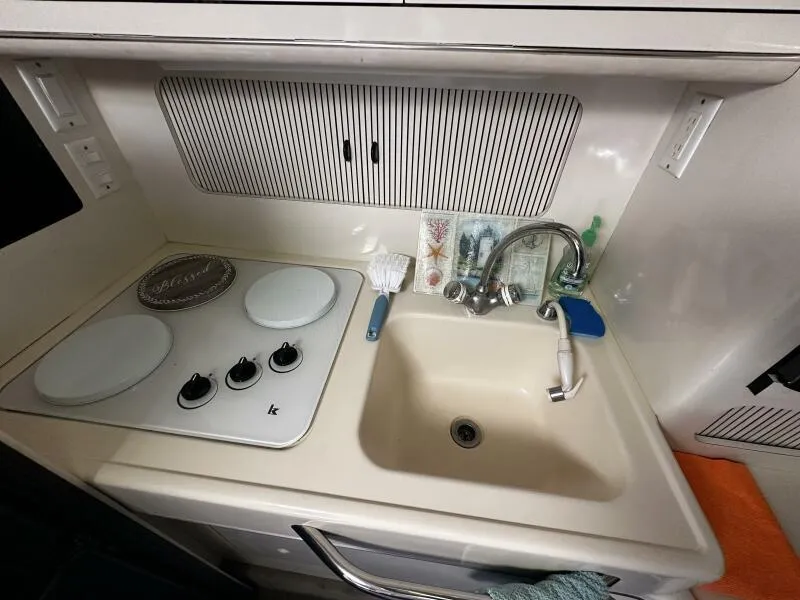 Slide: The Image of 1996 Sea Ray 400 Express Cruiser kitchen with stove and sink. - 41