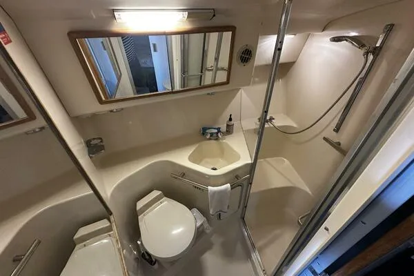 Slide: The Image of Bathroom of 1996 Sea Ray 400 Express Cruiser with shower, toilet, and sink. - 46