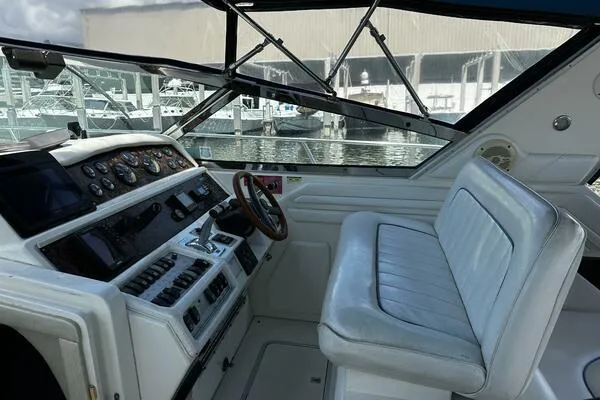 Slide: The Image of 1996 Sea Ray 400 Express Cruiser helm with leather seating and control panel. - 5