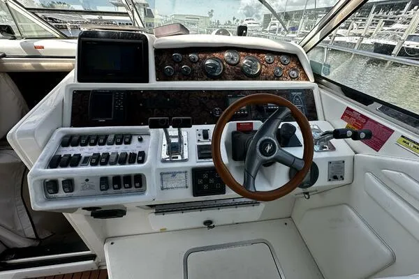 Slide: The Image of 1996 Sea Ray 400 Express Cruiser helm with controls and wooden steering wheel. - 6