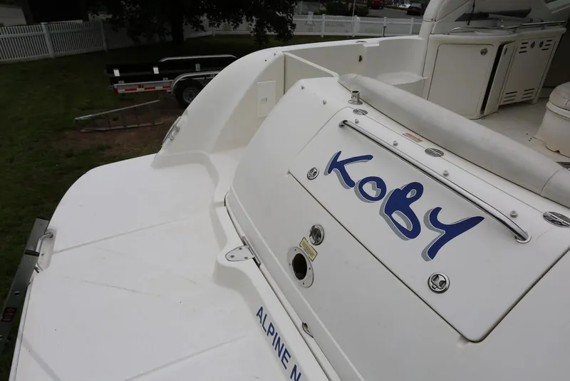 Slide: The Image of 2003 Sea Ray 420 Sundancer boat with "Koby" name on the stern, docked outdoors. - 10