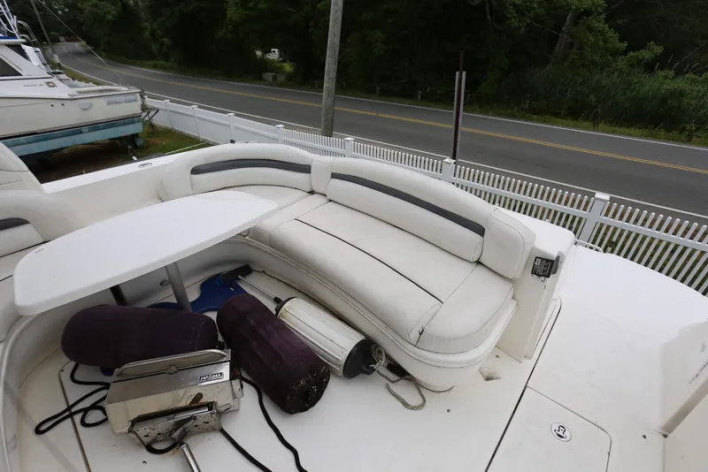 Slide: The Image of 2003 Sea Ray 420 Sundancer boat with white seating and table on deck. - 15