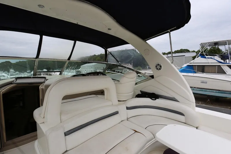 Slide: The Image of 2003 Sea Ray 420 Sundancer interior with white seating and marina view. - 18