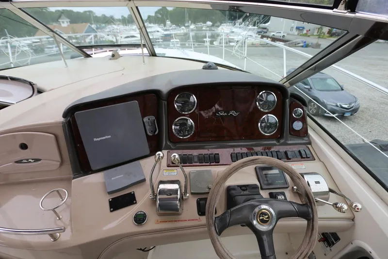 Slide: The Image of 2003 Sea Ray 420 Sundancer helm with steering wheel, gauges, and navigation equipment. - 26