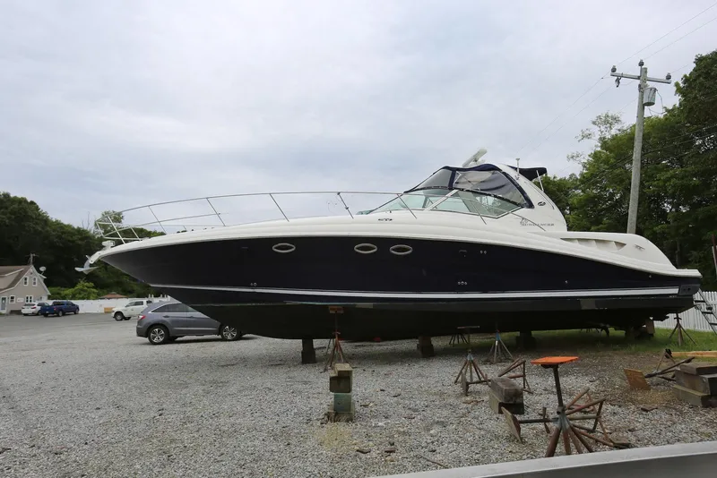 Slide: The Image of 2003 Sea Ray 420 Sundancer yacht on dry dock, gravel lot, overcast sky. - 3