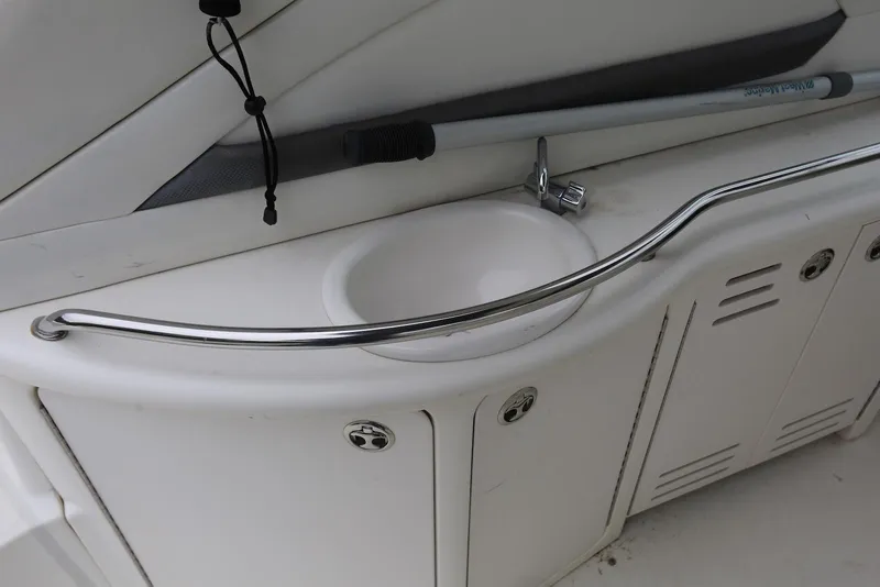 Slide: The Image of 2003 Sea Ray 420 Sundancer boat sink with chrome rail and storage cabinets. - 35