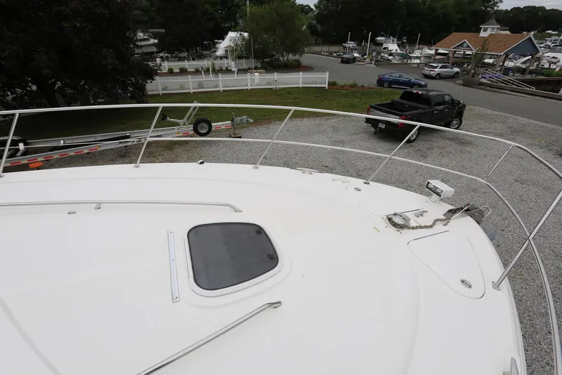 Slide: The Image of 2003 Sea Ray 420 Sundancer yacht on gravel, with truck and trailer nearby. - 43