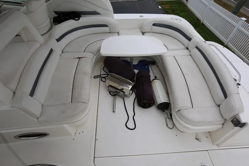 Slide: The Image of 2003 Sea Ray 420 Sundancer boat seating area with white cushions and table. - 46